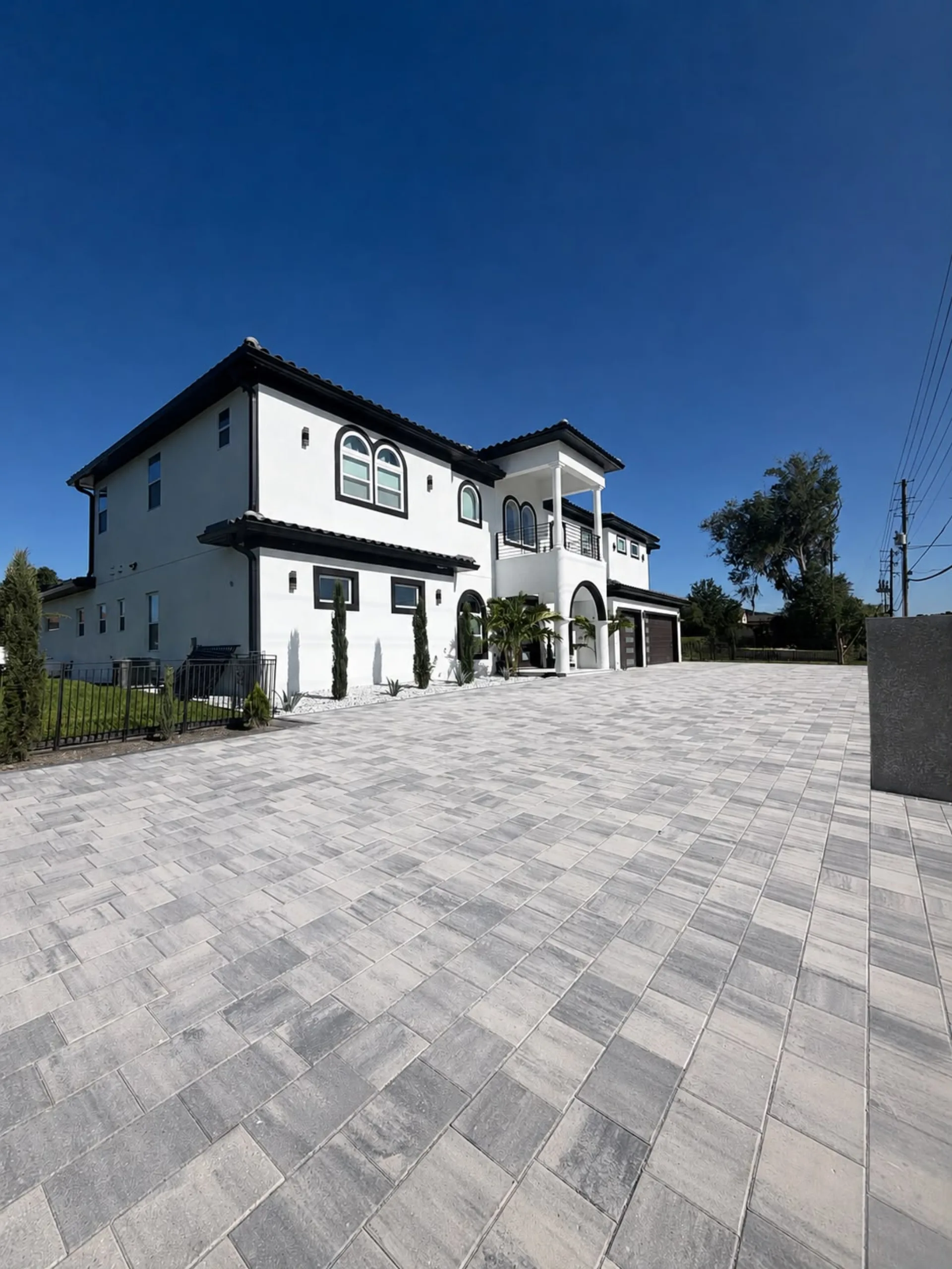 Modern Brevard County home with a custom gray paver driveway by Golden Outdoor Solutions