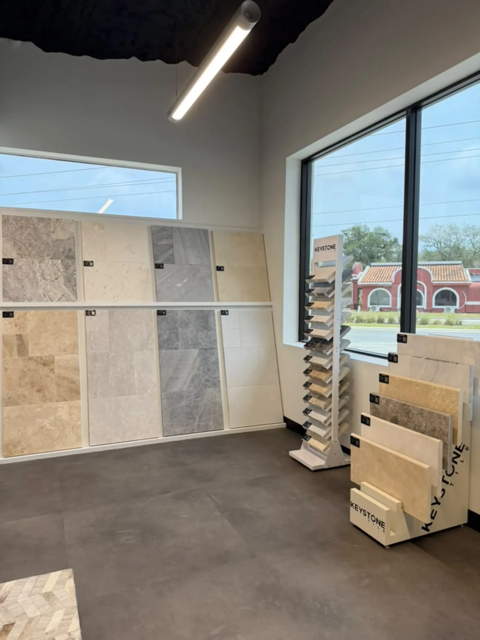 Inside the Golden Outdoor Solutions showroom in Melbourne, FL, with travertine and marble tile samples