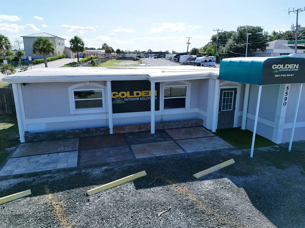 Golden Outdoor Solutions showroom storefront at 5590 N US Hwy 1 in Melbourne, FL, with paver samples out front